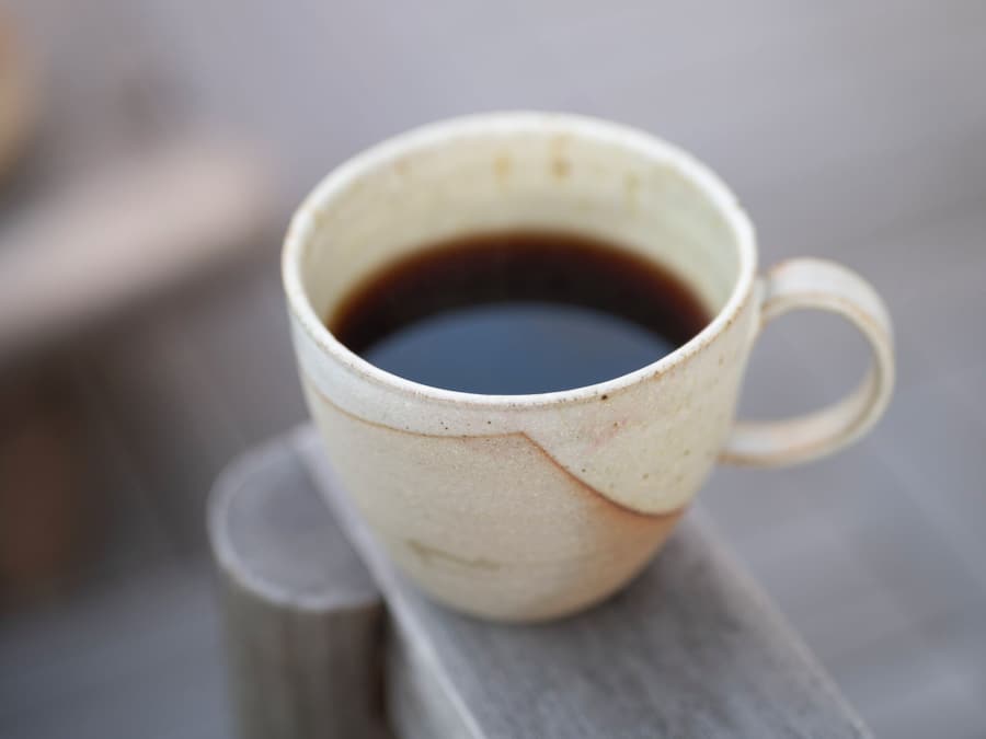 Une tasse de café sur une surface en bois.