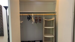 Armadio a muro con mensole aperte, spazio per appendere abiti e scaffale per scarpe.