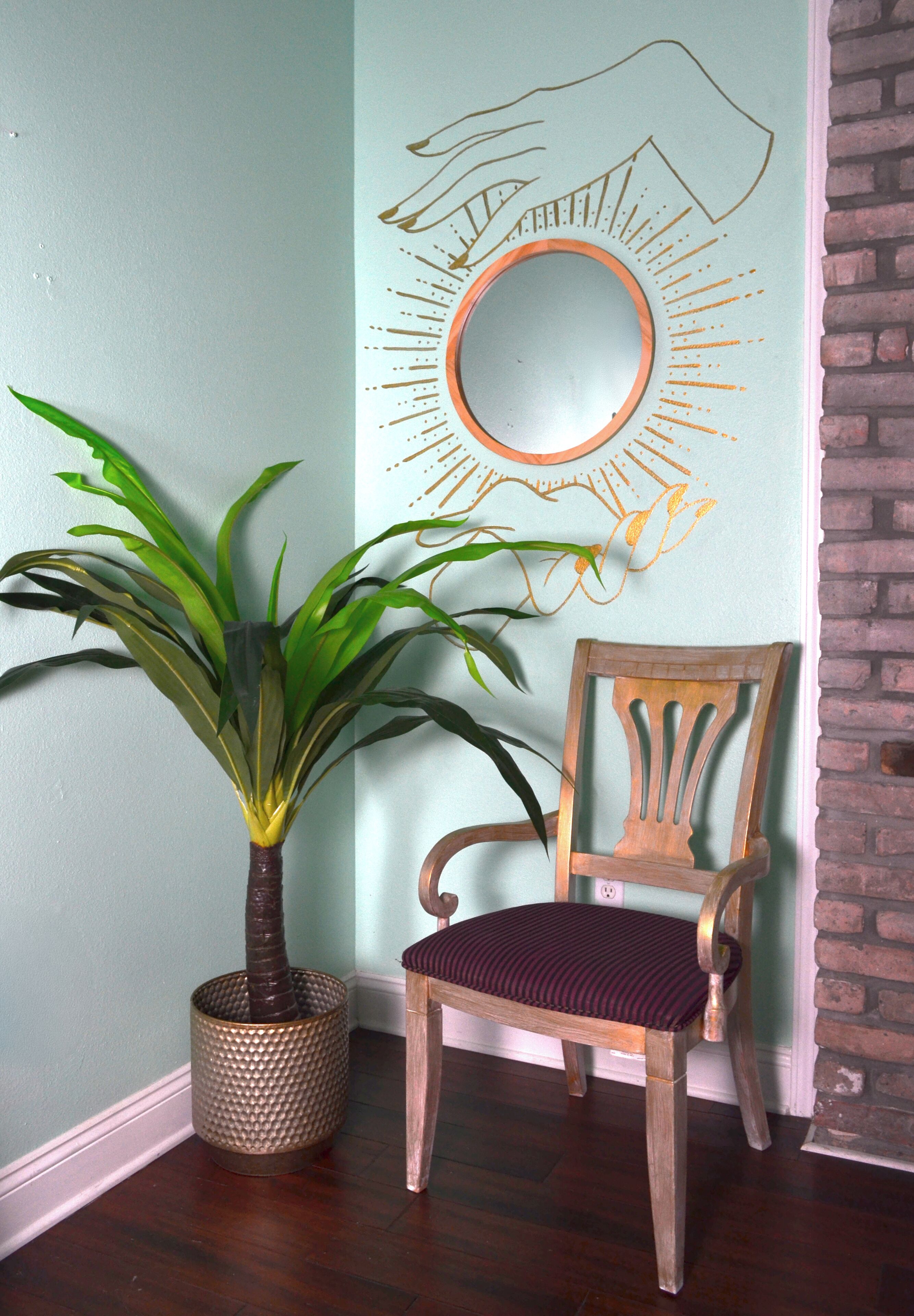 Una silla de madera con asiento y respaldo acolchados, ubicada junto a una planta en maceta de hojas anchas.