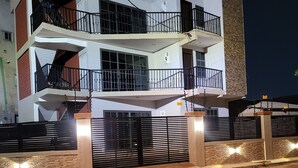 Un immeuble à plusieurs étages doté de balcons, d’une entrée sécurisée et d’une façade en pierre.
