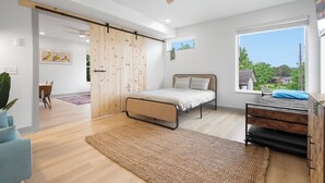 A modern bedroom with a bed, a desk, a window, and a ceiling fan. - Luxury modern 3bd/3ba, sauna, EV charger, 15mi BNA 7mi Broadway 6mi Vandy (Nashville)