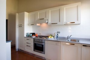 A modern kitchen with white cabinetry, a gas stove, an oven, a dishwasher, and a sink.