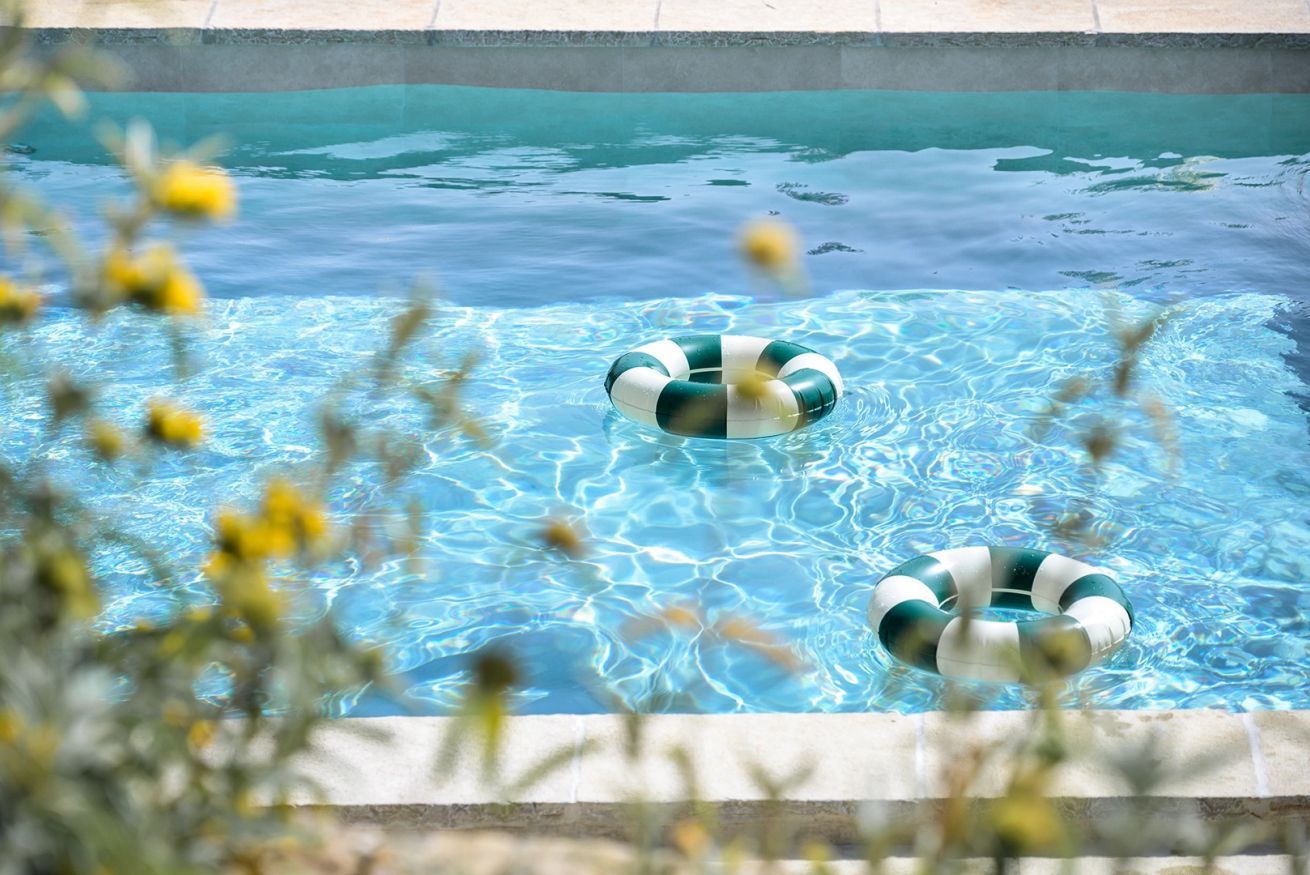 Une piscine à l’eau claire avec deux bouées.