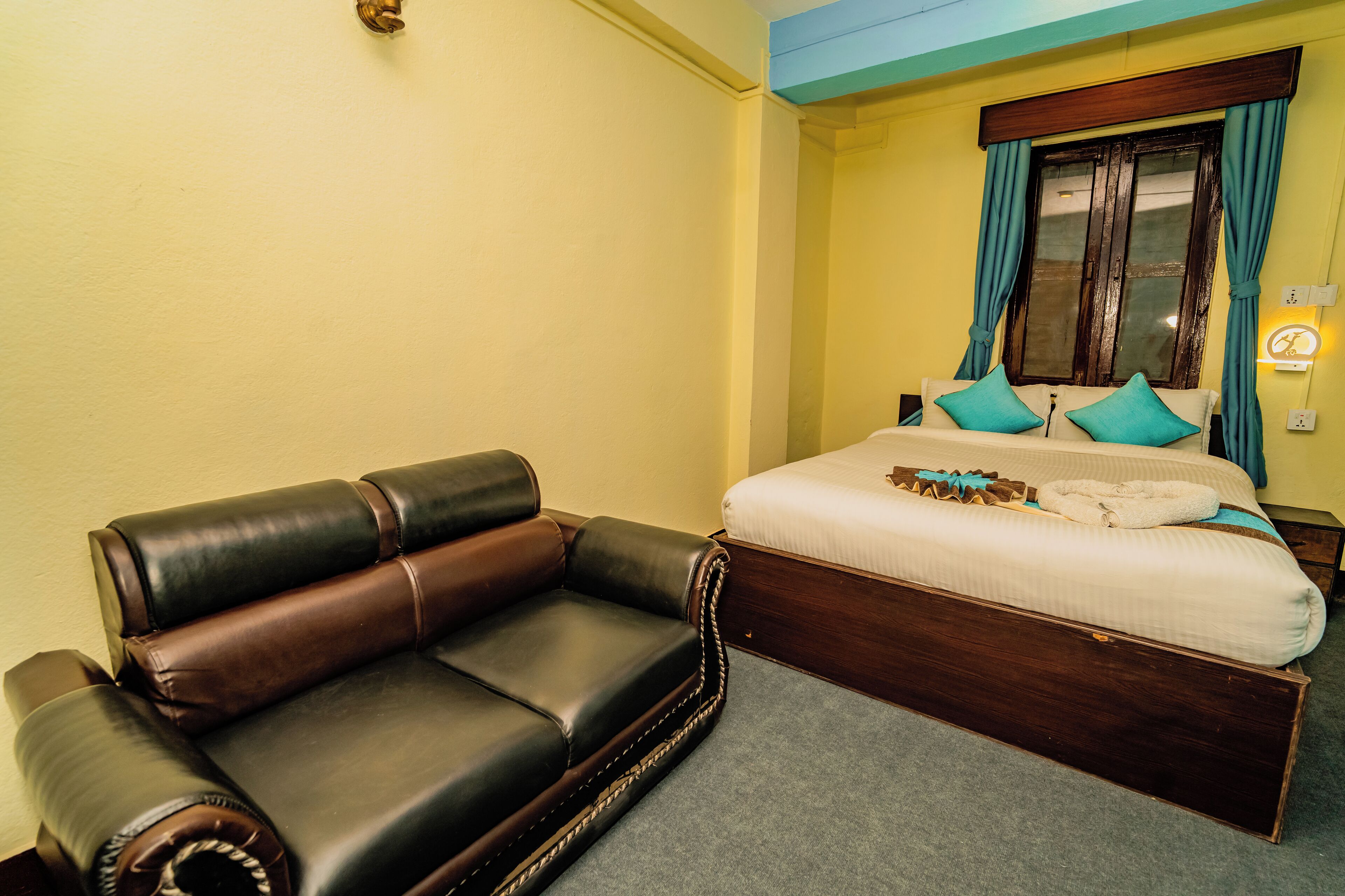 A hotel room with a bed, a sofa, and a nightstand.
