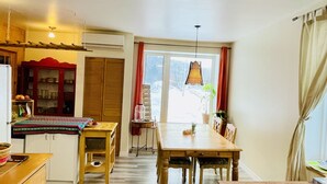 Une cuisine spacieuse avec des meubles en bois, une table à manger et une vue sur un paysage enneigé par la fenêtre.
