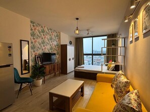 Relax in this stylish living room with a sofa, flat-screen TV, and city view.