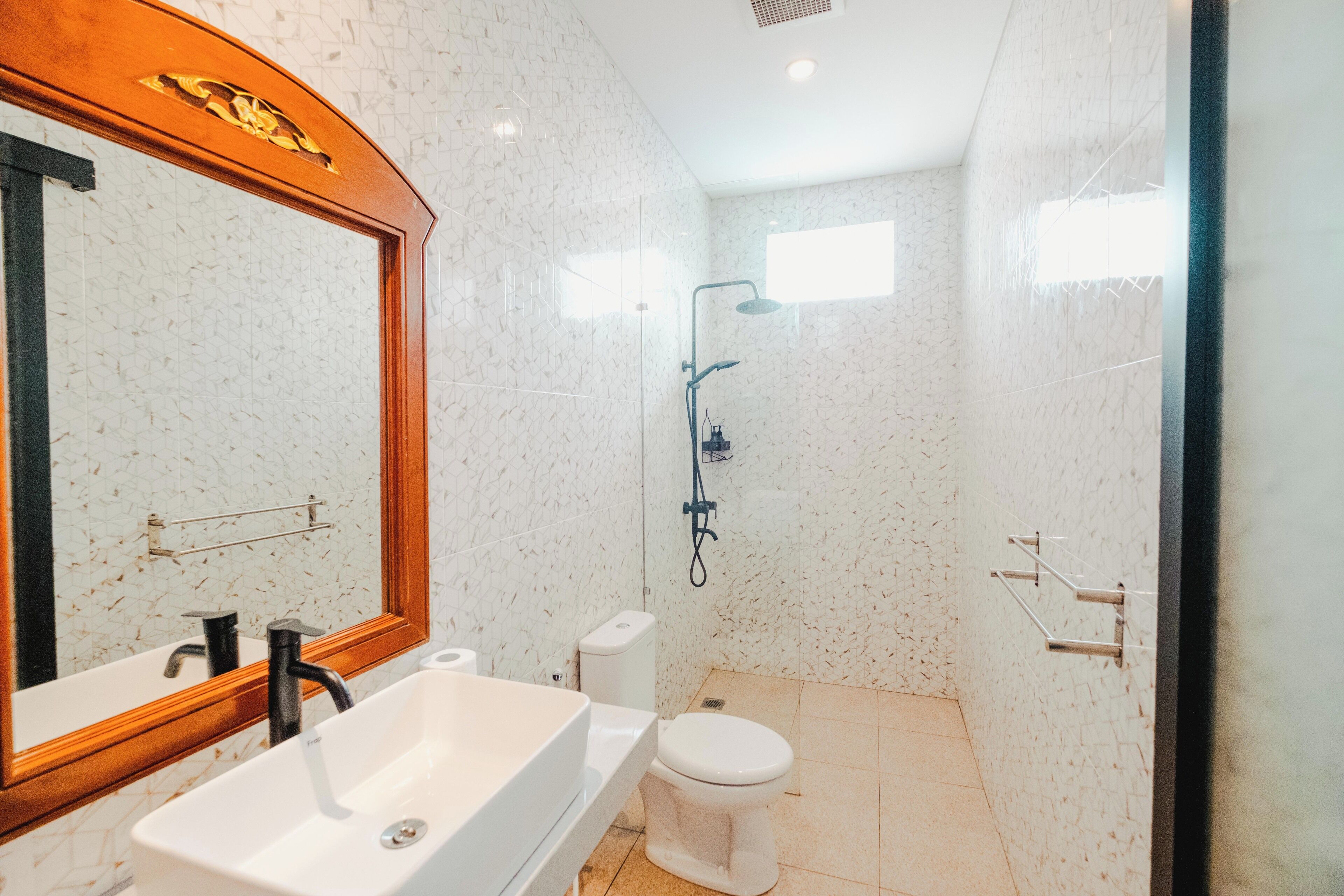 A modern bathroom with a freestanding sink, a toilet, and a shower.