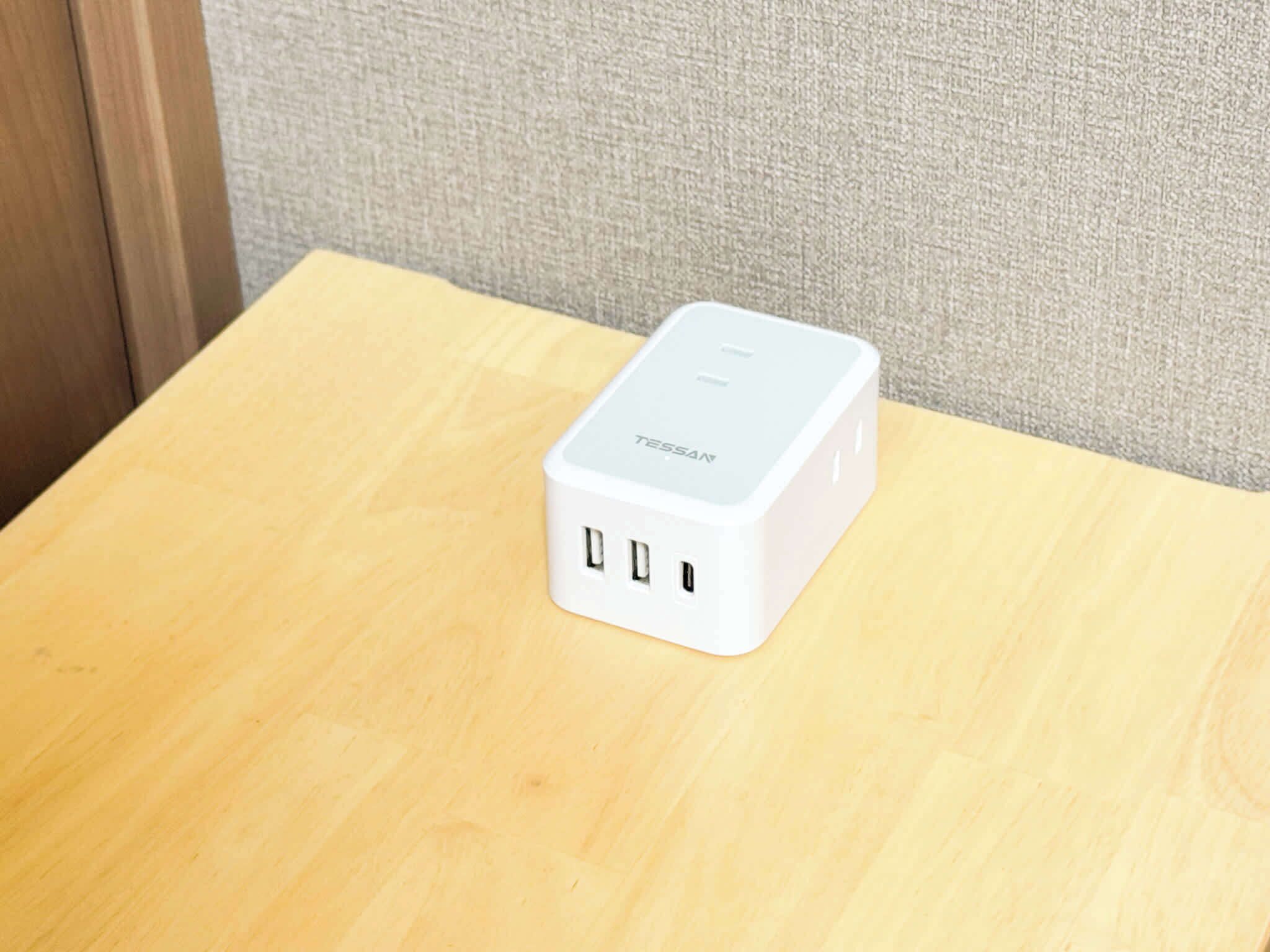 A white electronic device on a wooden table.