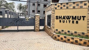 A gated entrance to Shawmut Suites with a stone and brick facade, a metal gate, and a clear sky in the background. - Shawmut Suites Nakuru (Nakuru)