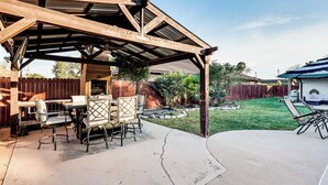 A covered patio with a wooden table and chairs, a concrete floor, and a fenced backyard. - 3 Mi to Downtown McAllen: Quiet Home w/ Pool (McAllen)