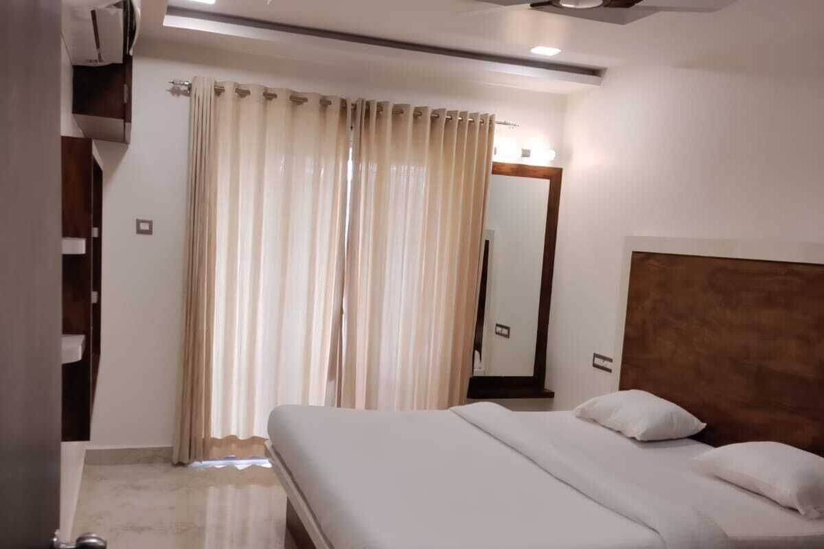 A bedroom with a bed, a ceiling fan, and a bathroom with a shower.