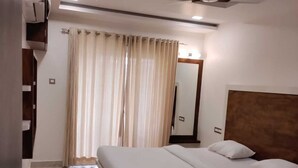 Un dormitorio con cama, ventilador de techo y baño con ducha.