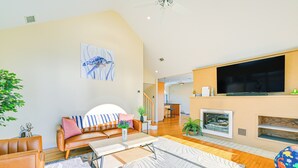 Een moderne woonkamer met een bank, salontafel en een flatscreen televisie aan de muur.