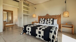 A bedroom with a large bed, wooden headboard, two bedside tables, a mirror, and a hanging light fixture. - Alea Estate by Villa Finder (Kerobokan)