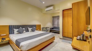 A modern hotel room with a large bed, bedside tables, a desk, and a wardrobe. - VITS Select Nashik (Nashik)