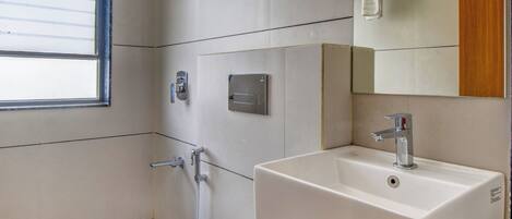 A modern bathroom with a toilet, sink, and shower.