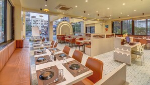 A modern restaurant with a long counter, booths, and a high ceiling with recessed lighting. - VITS Select Nashik (Nashik)