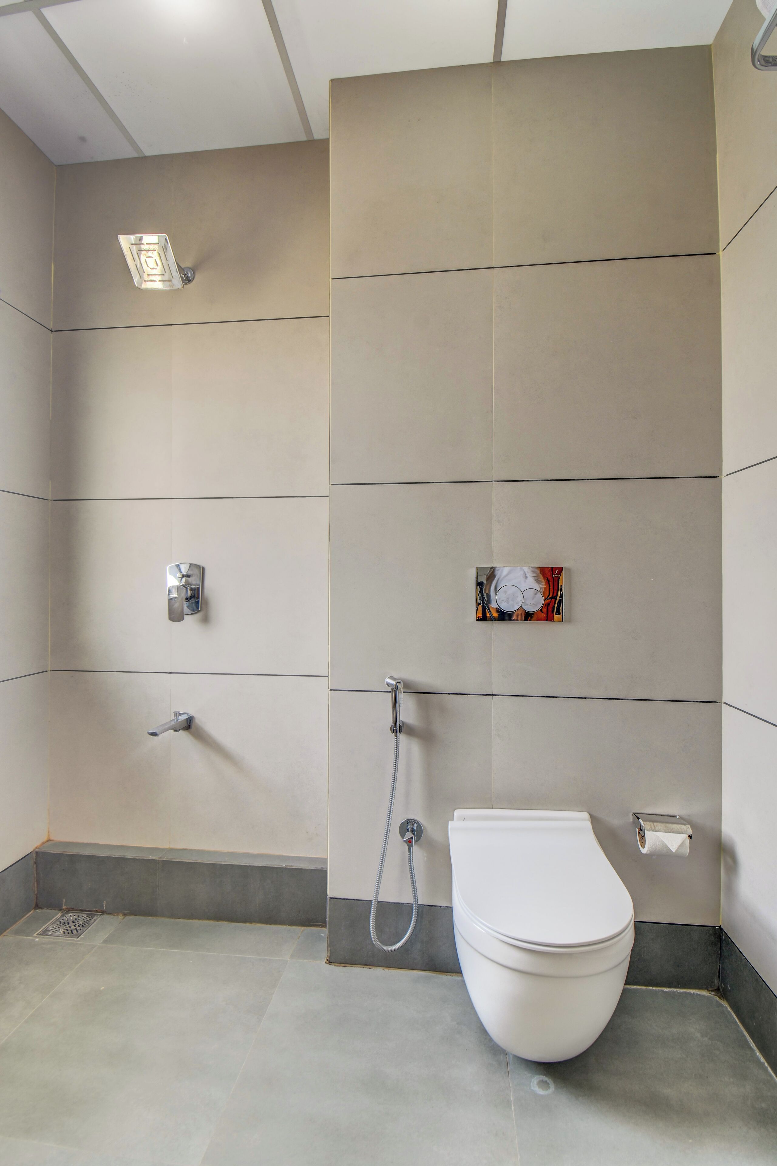 Un baño moderno con inodoro, ducha y dispensador de toallas de pared.