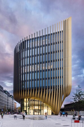 Een modern gebouw met een bijzondere, gebogen gevel en een glazen entree.