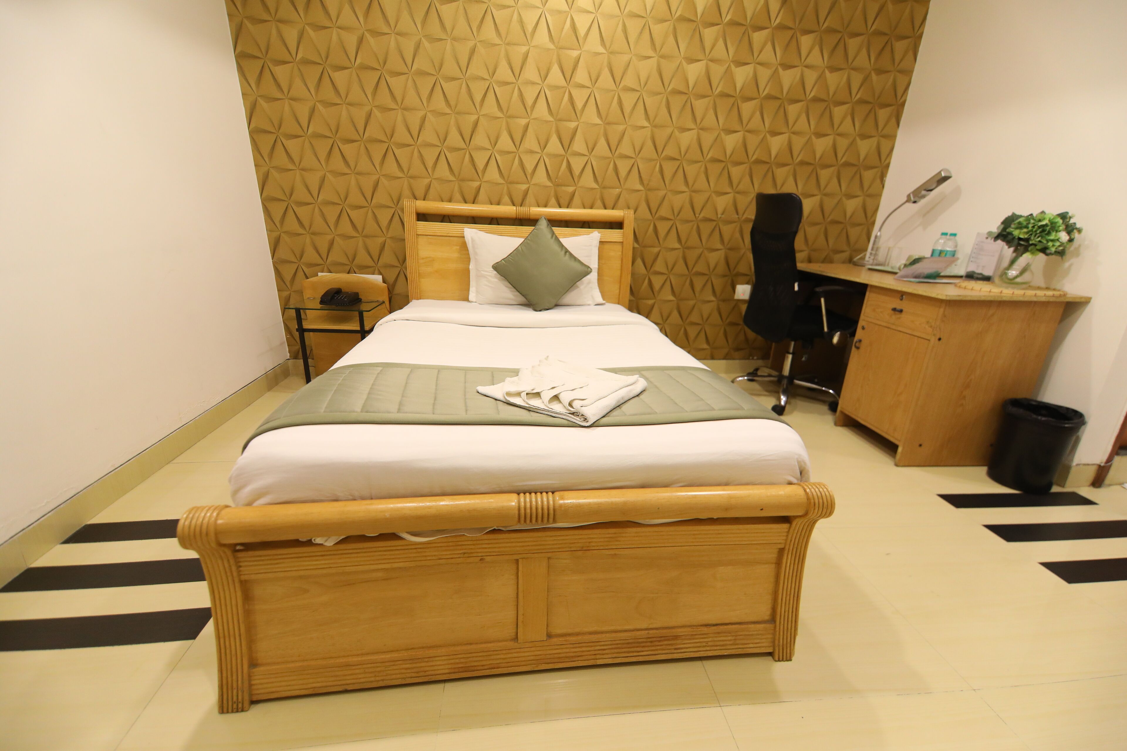 Un dormitorio ordenado con una cama, un escritorio y una silla.
