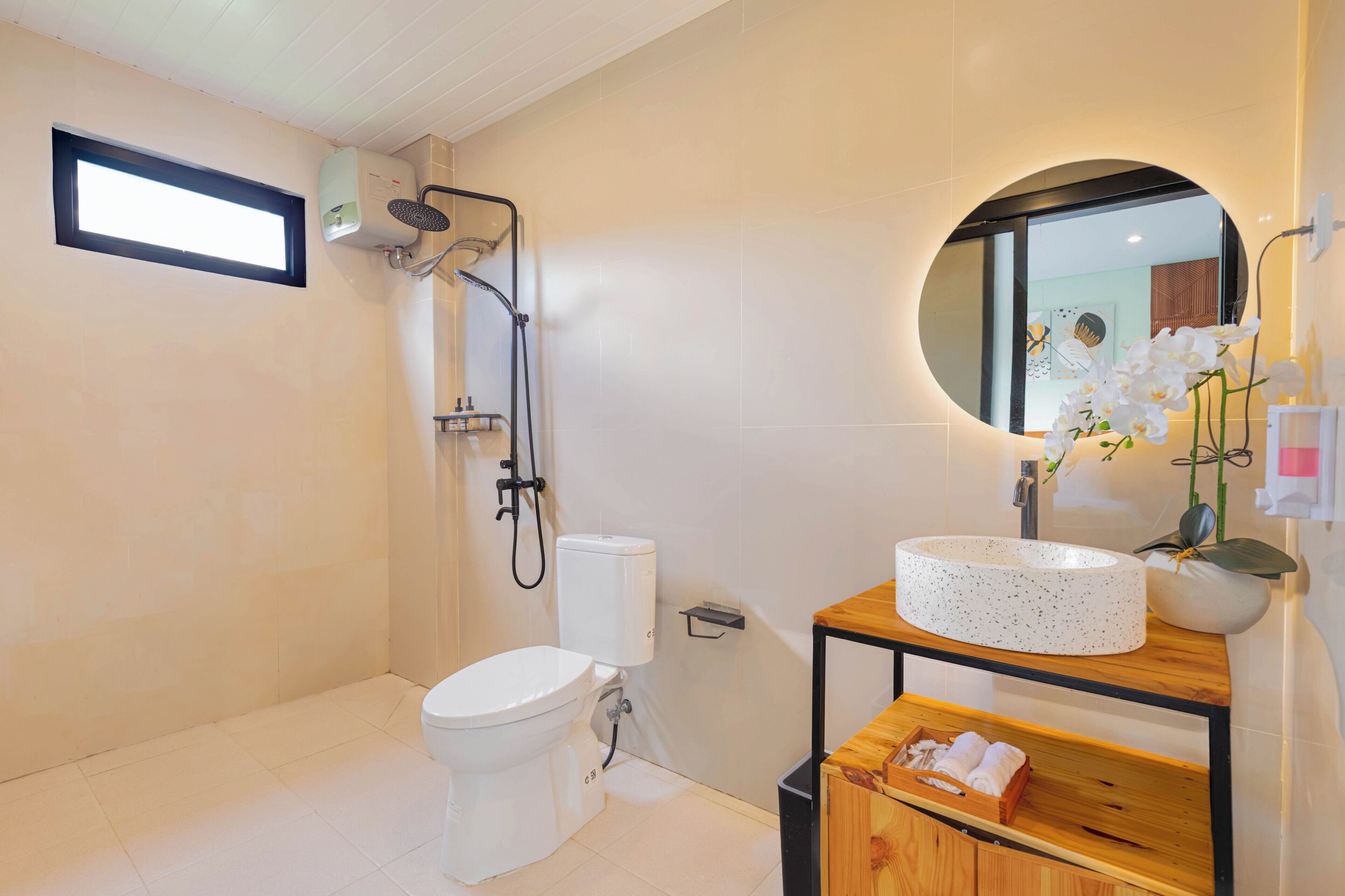 Une salle de bain moderne équipée de toilettes, d’une douche et d’un lavabo.