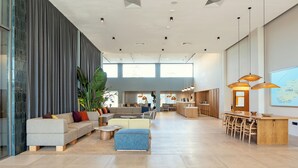 Un espace de vie spacieux et moderne, comprenant un canapé, une table basse et un coin repas avec une table et des chaises en bois.