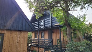 Eine Holzhütte mit einem Balkon und einer Treppe zum Eingang.