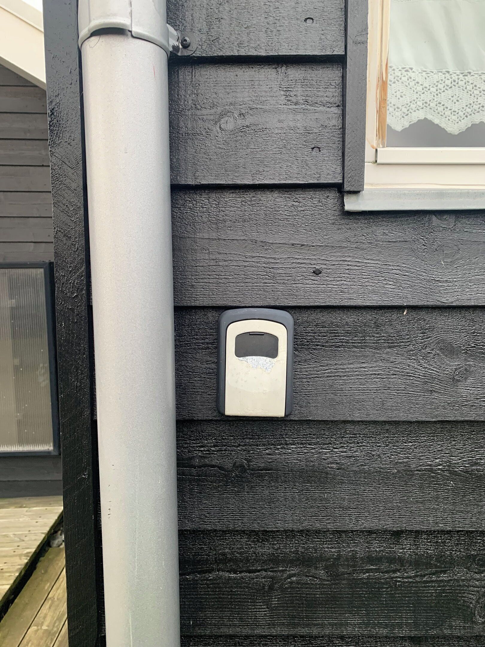Ein Haus mit einem an einer Holzwand montierten Metallbriefkasten.