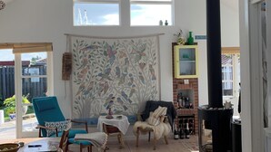 Ein Zimmer mit hoher Decke, großem Fenster, Kamin und Essbereich.