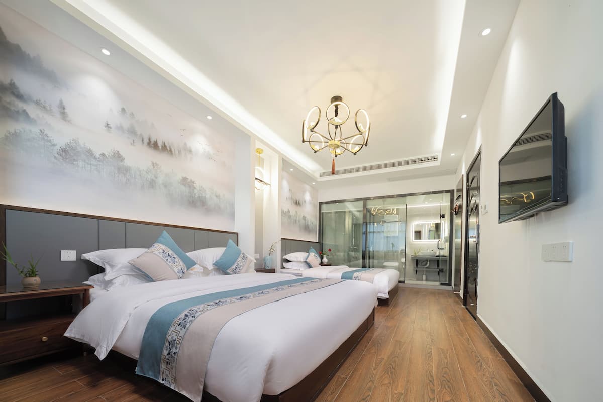 Un dormitorio moderno con una cama grande, un vestidor y un baño con separador de vidrio.