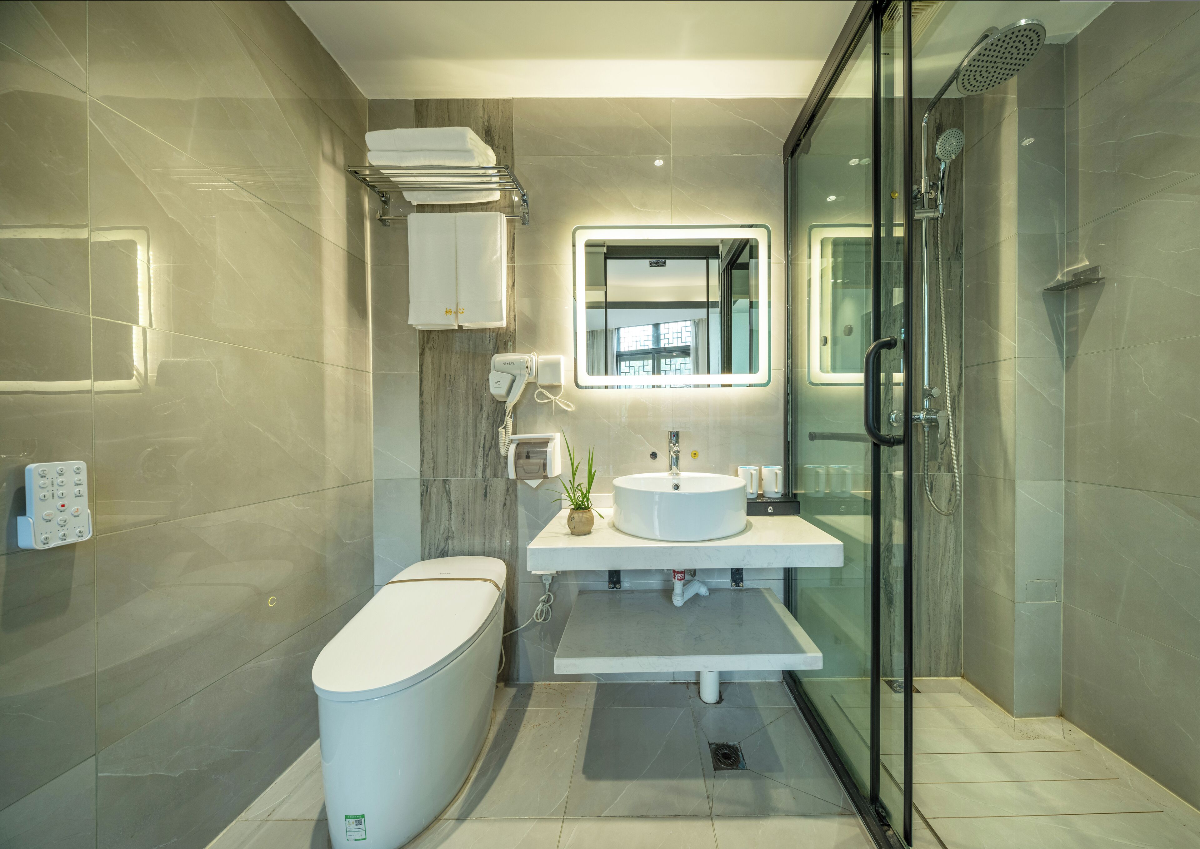 A modern bathroom with a toilet, sink, and shower.