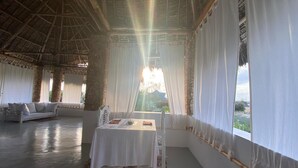 A room with a table set for two, a sofa, and a large window with curtains. - MUMBI VILLA WATAMU (Watamu)