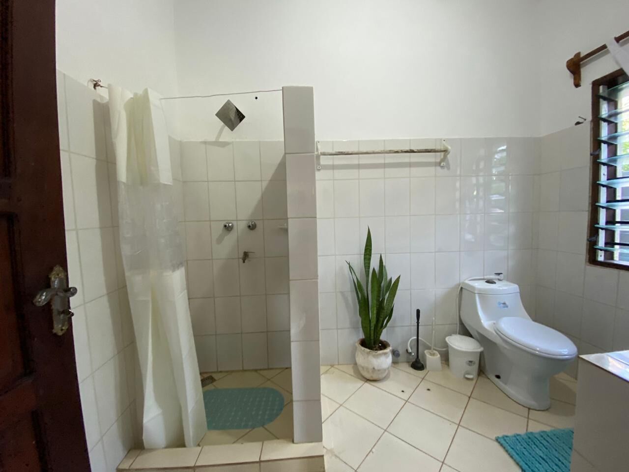 Une salle de bain avec douche, toilettes et lavabo.