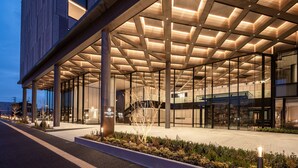 A modern hotel entrance with a covered walkway, large pillars, and a sign indicating the hotel name. - ATAGO HOTEL (Noda)