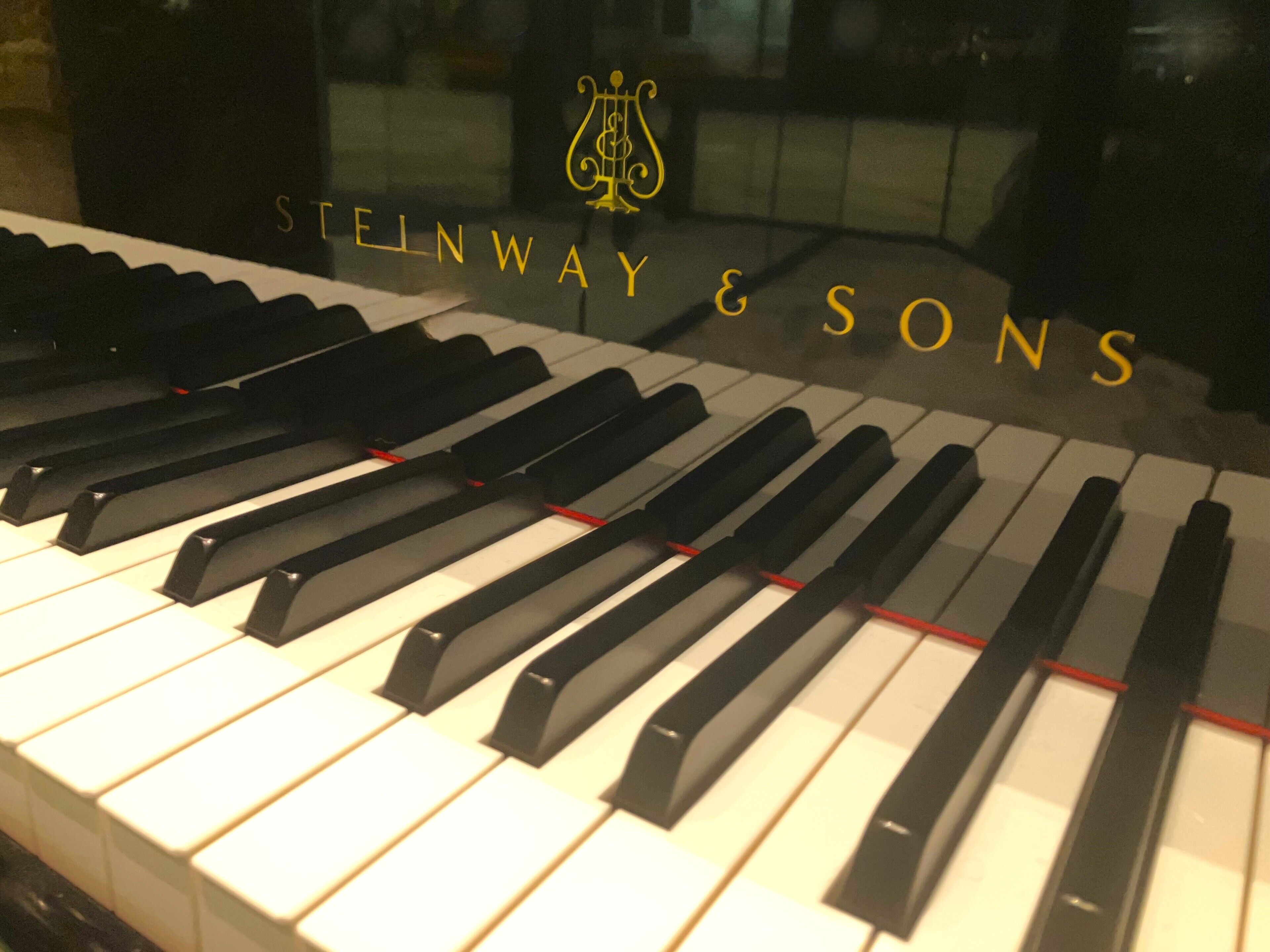 Een piano met zwart en wit toetsen en het logo "Steinway & Sons" op de zijkant.