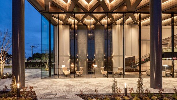 A modern building with a glass facade, a geometric ceiling design, and a spacious interior with seating areas. - ATAGO HOTEL (Noda)