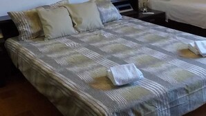A bedroom with a bed, a nightstand, a bedside table, and a wall-mounted air conditioner. - B&B the bikers (Guspini)