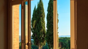Une porte qui donne sur un jardin, d’où l’on a une vue dégagée sur les arbres et une pelouse.