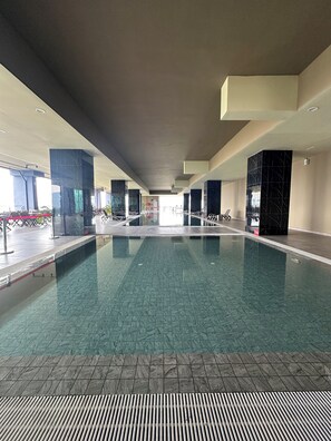 An indoor swimming pool with clear water, surrounded by tiled walls and pillars. - ICC Luxury Suites Ipoh City Centre (Ipoh)