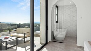A modern bathroom with a glass-enclosed shower and a view of the city.