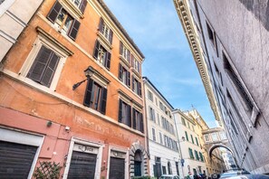 A narrow street with historic buildings, including a building with 'IL BUCO' signage.