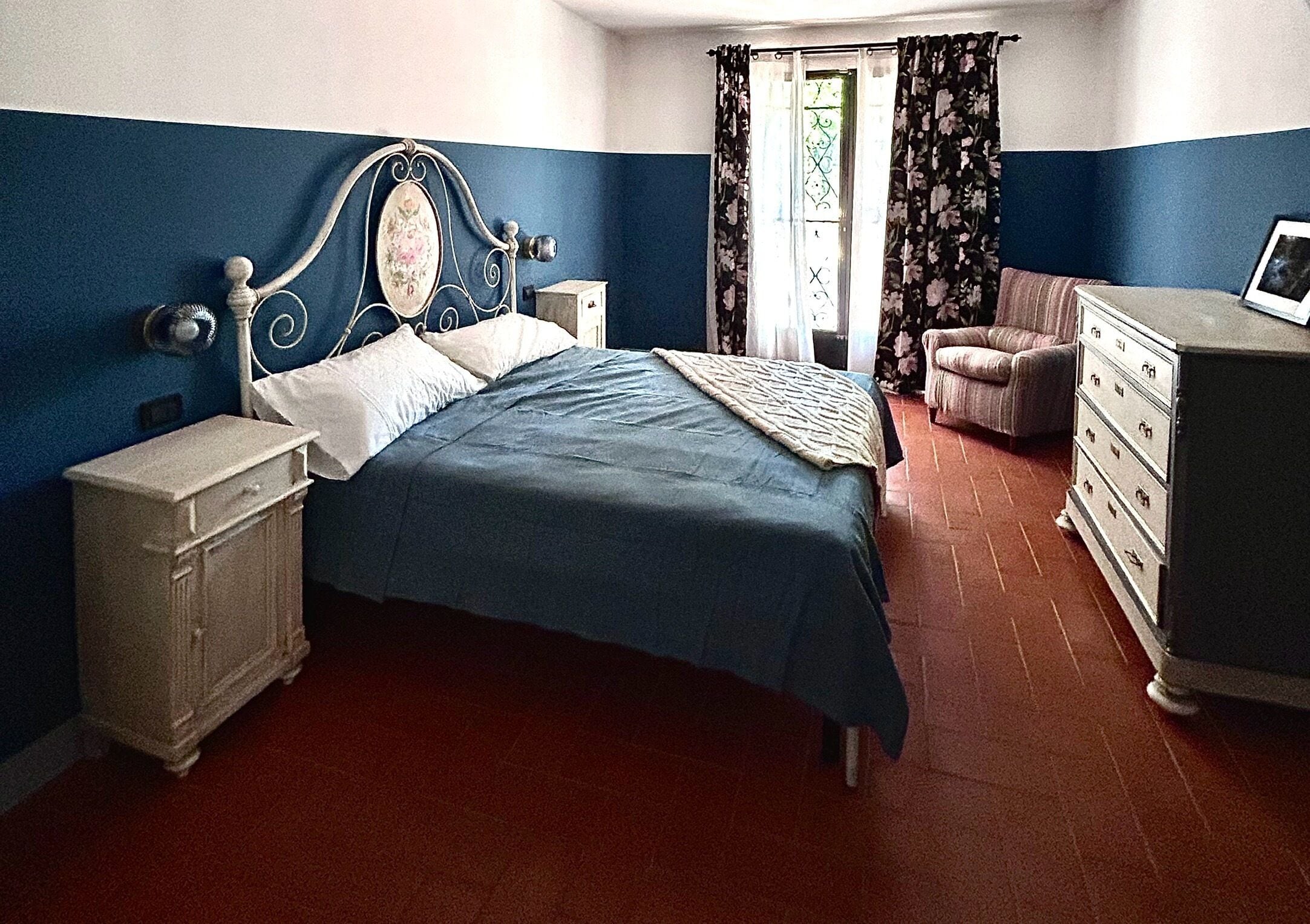 A bedroom with a bed, nightstands, a dresser, and a chair.