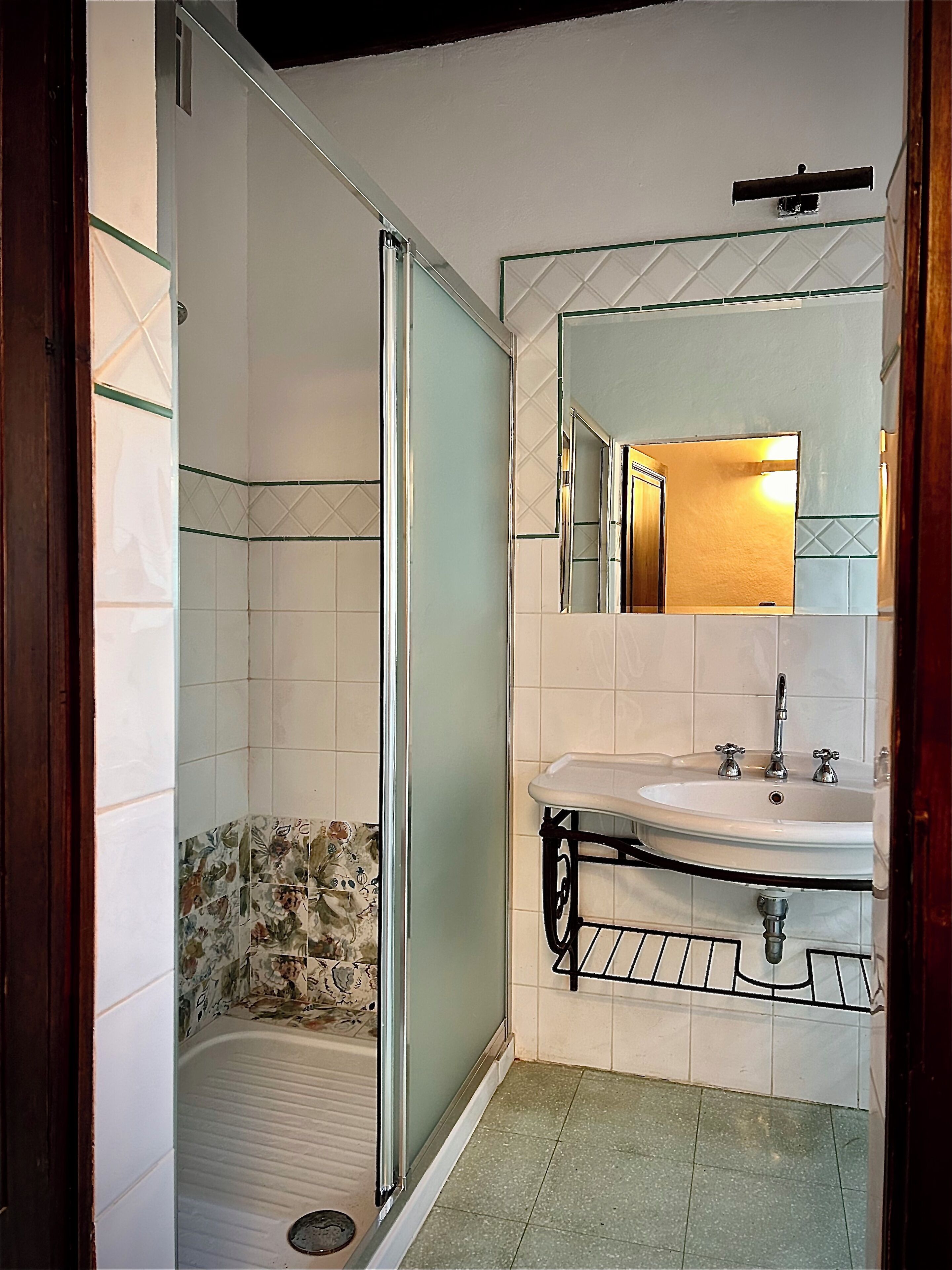 A bathroom with a shower, sink, and mirror.