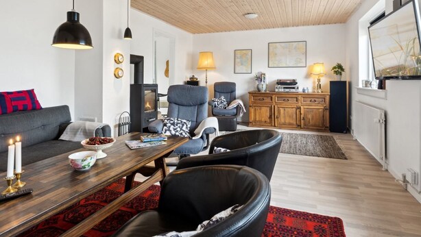 A cozy living room with a fireplace, a sofa, a dining table, and a TV.
