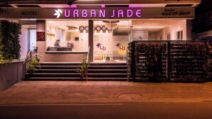 A hotel entrance with a neon sign reading "URBAN JADE" and a staircase leading up to the door. - Hotel Urban Jade (Bengaluru)