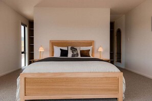 Un dormitorio con una cama de madera, dos lámparas de noche y un ventanal grande.