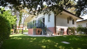 A modern house with a glass staircase leading to a covered outdoor area.