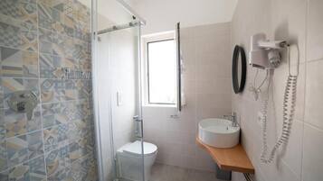 A bathroom with a shower, toilet, and sink.
