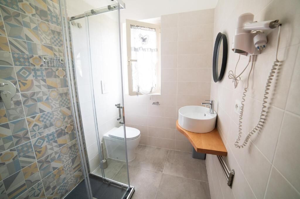 A bathroom with a shower, toilet, and sink.