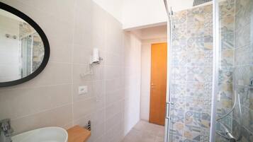 Ein Badezimmer mit Badewanne, Dusche, Toilette und Spiegel.